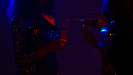 Nahaufnahme-Von-Zwei-Frauen-In-Einer-Nachtclubbar-Oder-Disco,-Die-Getränke-Aus-Flasche-1-Einschenken
